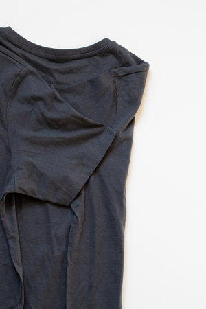 Dark blue crumpled short-sleeved T-shirt lies on a white background, casual T-shirt, clothingの写真素材