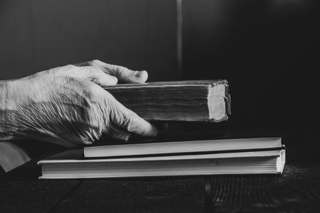 Elderly woman reading a book at the table at home, black and white photo, readingの写真素材
