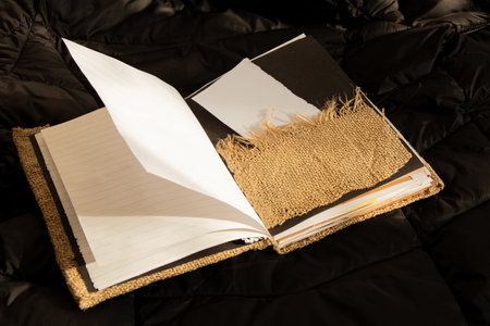 Blank diy notebook with kraft paper and burlap cover lies on black soft fabric,notebookの写真素材