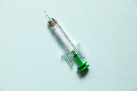 Pre-filled syringe lies on blue background, syringe for injection, medicine and treatmentの写真素材
