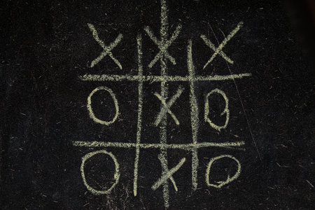 Children's game tic-tac-toe drawn on a school blackboard, play tic-tac-toe