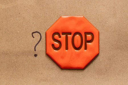 Hand drawn question mark and reflexive sign with stop text on brown paper, question