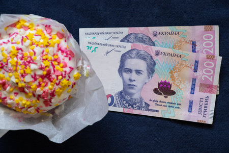 Easter cake and two hundred hryvnia bills on a blue background, Easter expenses, expenses and money