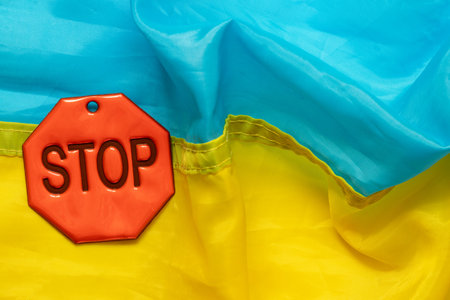 Red stop sign on blue and yellow Ukrainian flag background, concept of restriction, protest or warningの写真素材
