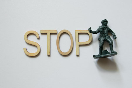 Word stop made of wooden letters and green plastic soldier on white background, concept against war, stop warの写真素材