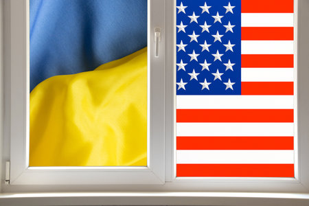 Window with the flags of the USA and Ukraine behind it, as a metaphor for the friendship and unity of the two countries looking to a common futureの写真素材