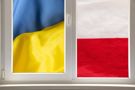 Flags of Ukraine and Poland outside the window, symbolizing openness, union and friendship between neighboring nationsの写真素材