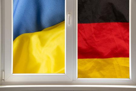 Flags of Ukraine and Germany outside the window, symbolizing the union, mutual understanding and the path to a common bright futureの写真素材