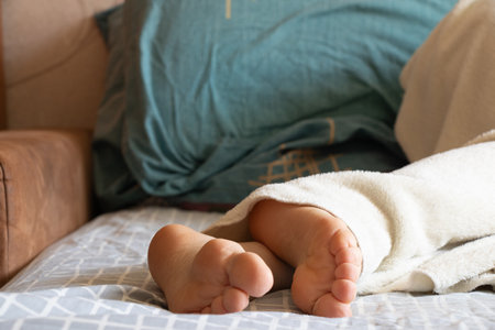 Legs of a girl on a bed sleeping, girl sleeping, rest at home, women's legsの写真素材