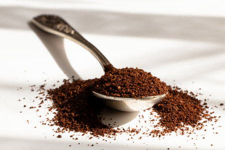 Old spoon with ground coffee in sunlight, aroma of the beginning of the day, scattered ground coffeeの写真素材