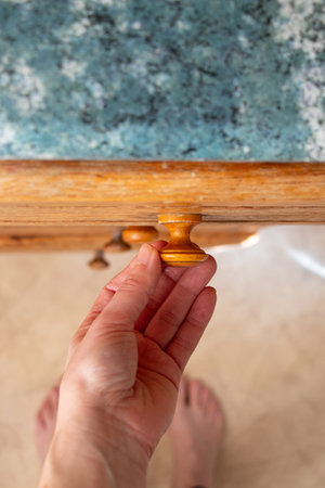 Woman's hand opens old kitchen drawer in kitchen at home top down view, kitchen furnitureの写真素材