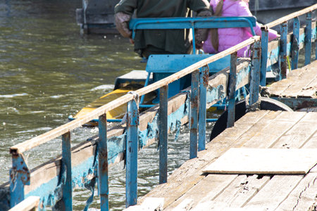 An old catamaran moors at a pier on the banks of the Dnieper River in Ukraine in springの写真素材