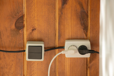 Socket and switch on a wooden wall outside, household plastic socketsの写真素材