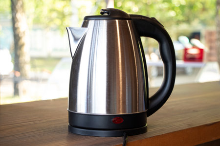 Electric steel kettle stands on the table outside on the bar counterの写真素材