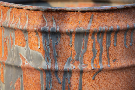 Rusty barrel with black paint drips as background close-up, rusty backgroundの写真素材