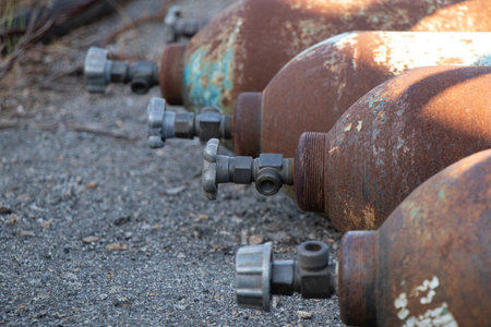 Old rusty cylinders lie on the asphalt on the street in the sun in Ukraineの写真素材