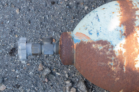 Old cylinder rusty lying on asphalt on the street in the sun in Ukraineの写真素材