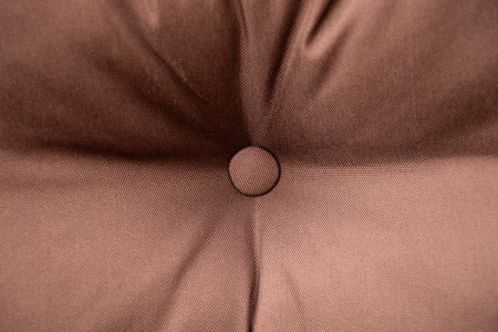 Soft brown pillow with a button in the middle close-upの写真素材