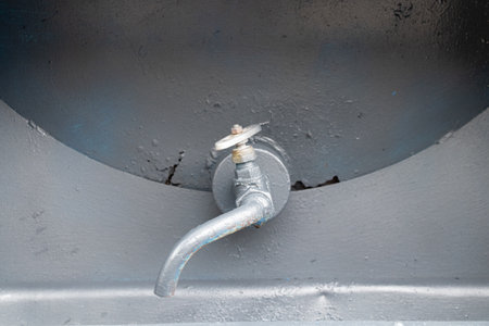 Old metal tap with a tube on a gray barrel close-upの写真素材