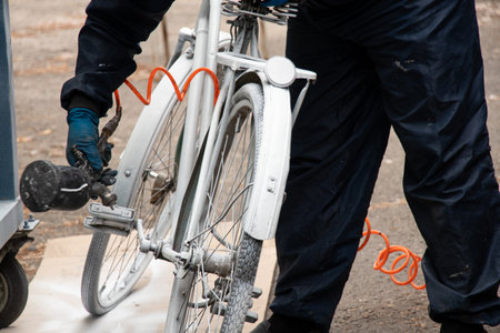 Painting an old bicycle with an airbrush outdoors in white, bicycle restoration, paintの写真素材