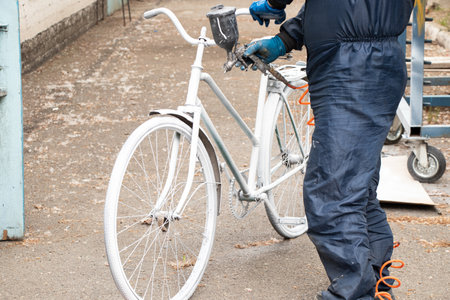 Painting an old bicycle with an airbrush outdoors in white, bicycle restoration, paintの写真素材
