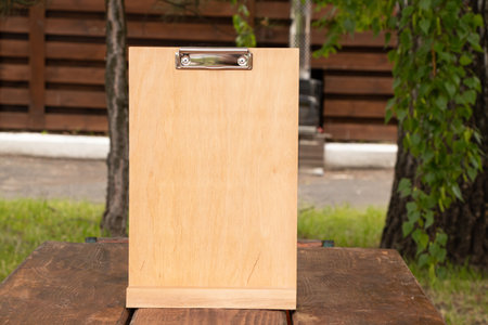 Empty wooden clipboard on table, empty space for advertisingの写真素材