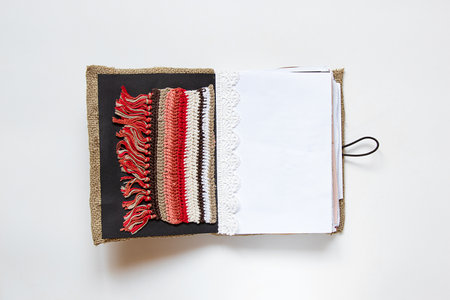 Open homemade notebook made of fabric and lace and different pages on white background, handmade notebookの写真素材
