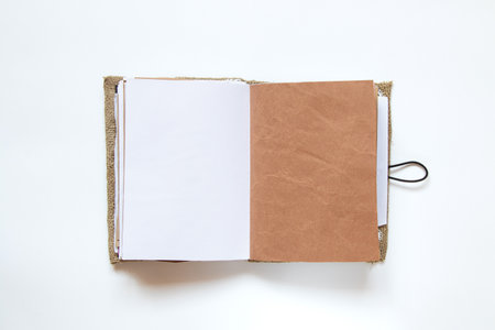 Open homemade notebook made of fabric and lace and different pages on white background, handmade notebookの写真素材