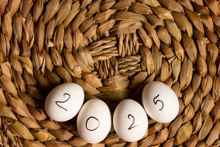 Eggs with the inscription 2025 lie on a straw wicker brown background, eggsの写真素材