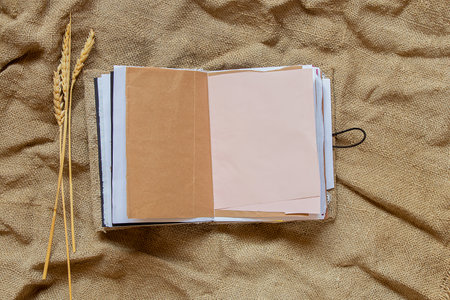Homemade open notebook with blank pages lies on burlapの写真素材