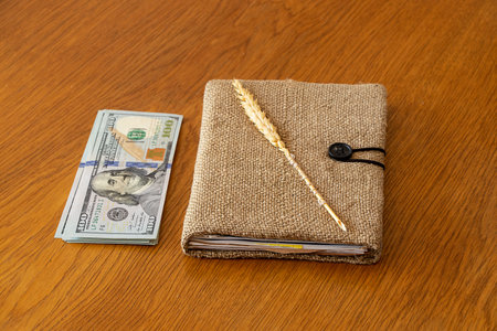 Handmade notebook and dollars are lying on the table, profit from handicraftsの写真素材