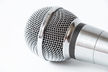 Professional silver microphone with cable on white background, studio equipment for sound recordingの写真素材