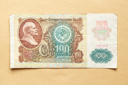 Vintage USSR banknote 100 rubles 1991 with a portrait of Lenin and the coat of arms on a craft background, old moneyの写真素材