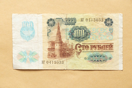 Vintage USSR banknote 100 rubles 1991 with a portrait of Lenin and the coat of arms on a craft background, old moneyの写真素材