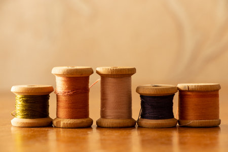 Wooden spools of threads of different colors on table at home, handicraft, sewing and textile creativity conceptの写真素材