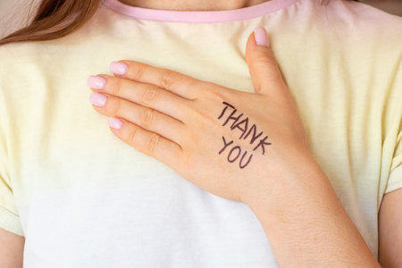 Female hand with the inscription thank you on the skin, a gesture of gratitude, gratitude to you from Ukraineの写真素材