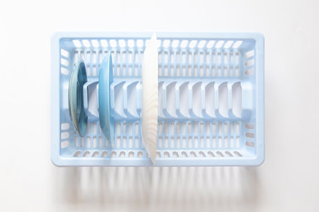 Plates in a blue plastic dish drainer in the kitchen, top view, cleanliness and home concept, clean dishesの写真素材