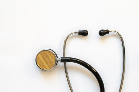 Black doctor stethoscope lies on a white background, medical equipment, space for textの写真素材
