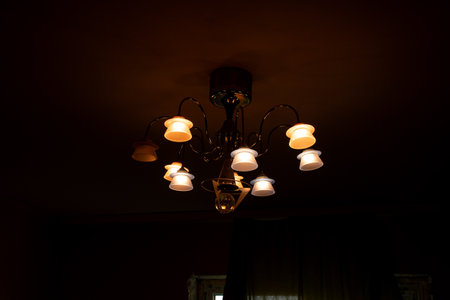 Chandelier on the ceiling in the apartment at night glows and illuminates the room, ceiling chandelierの写真素材