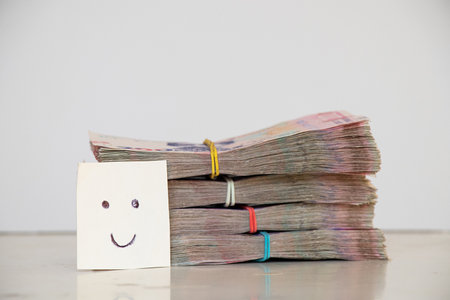 Packs of hryvnias with a denomination of 200 UAH and a smile drawn on paper, profit and incomeの写真素材