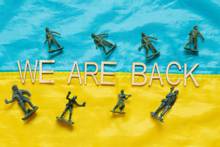 Flag of Ukraine with the inscription We are back and plastic soldiers, a symbol of the return of...