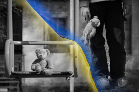 A child with a toy against the background of a children's toy on a playgroundの写真素材