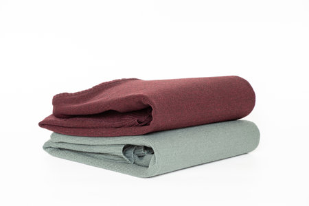 Folded pale green men's turtleneck sweater and red on a white background, clothes for a catalog or online storeの写真素材