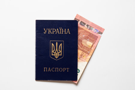 Ukrainian passport and 10 euro banknote on white background, financial aid, payments and supportの写真素材
