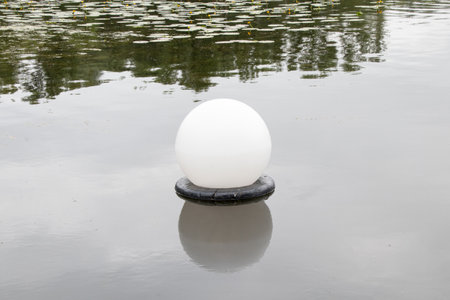 Floating round lamp for street lighting on water in Ukraine, an unusual solution for night lighting of a river or pondの写真素材