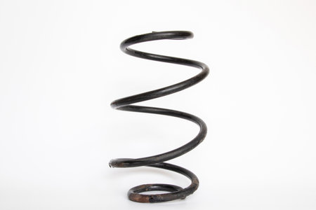 Worn out car suspension spring close-up on white background, replacement, repair, depreciation, car service and suspension parts themeの写真素材