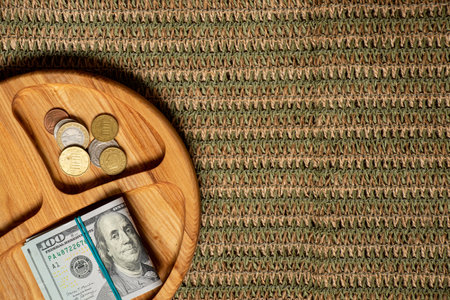 Wooden plate with dollars and coins on knitted background, finance, profit, savings and business calculations conceptの写真素材