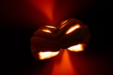 Candle in plaster female hands, symbol of memory, faith, sorrow and light in the darknessの写真素材