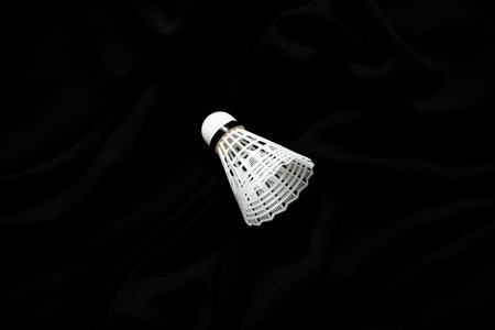 White badminton shuttlecock on black textile fabric close-upの写真素材