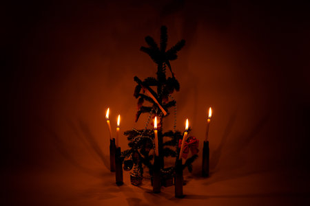 New Year tree with pine cones, garland, Ukrainian flag ribbon and candles on a dark background, symbols of holidayの写真素材
